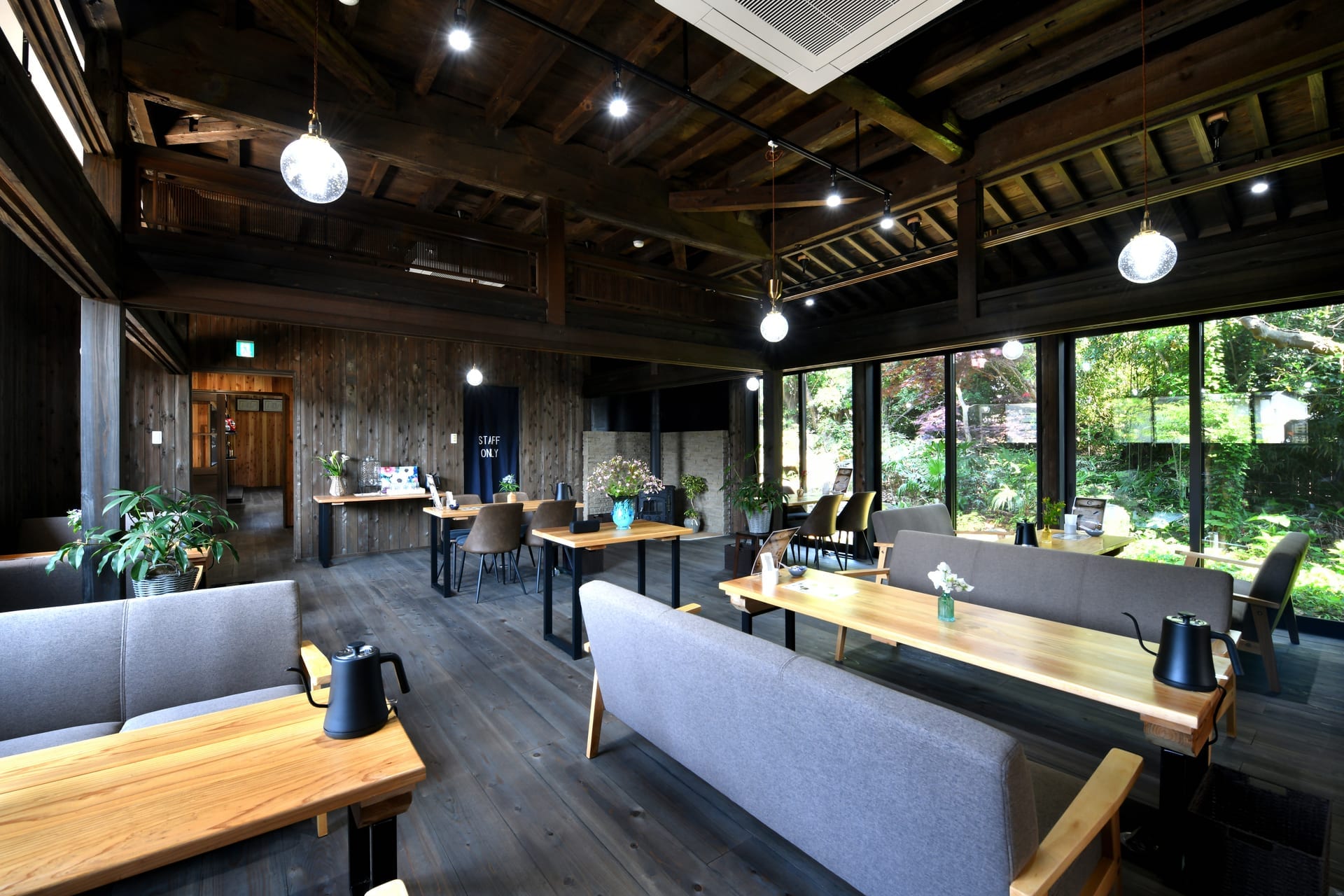 梁と庭の窓に囲まれたカフェの空間
